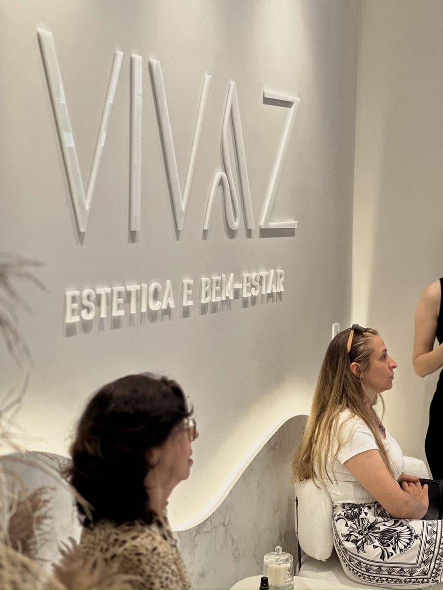 Convidadas na recepção durante a inauguração, com o logo da Vivaz na parede